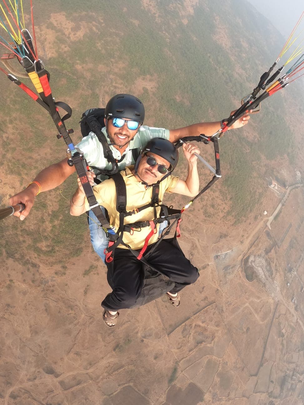Group of paragliding pilots preparing gear at Kamshet landing zone