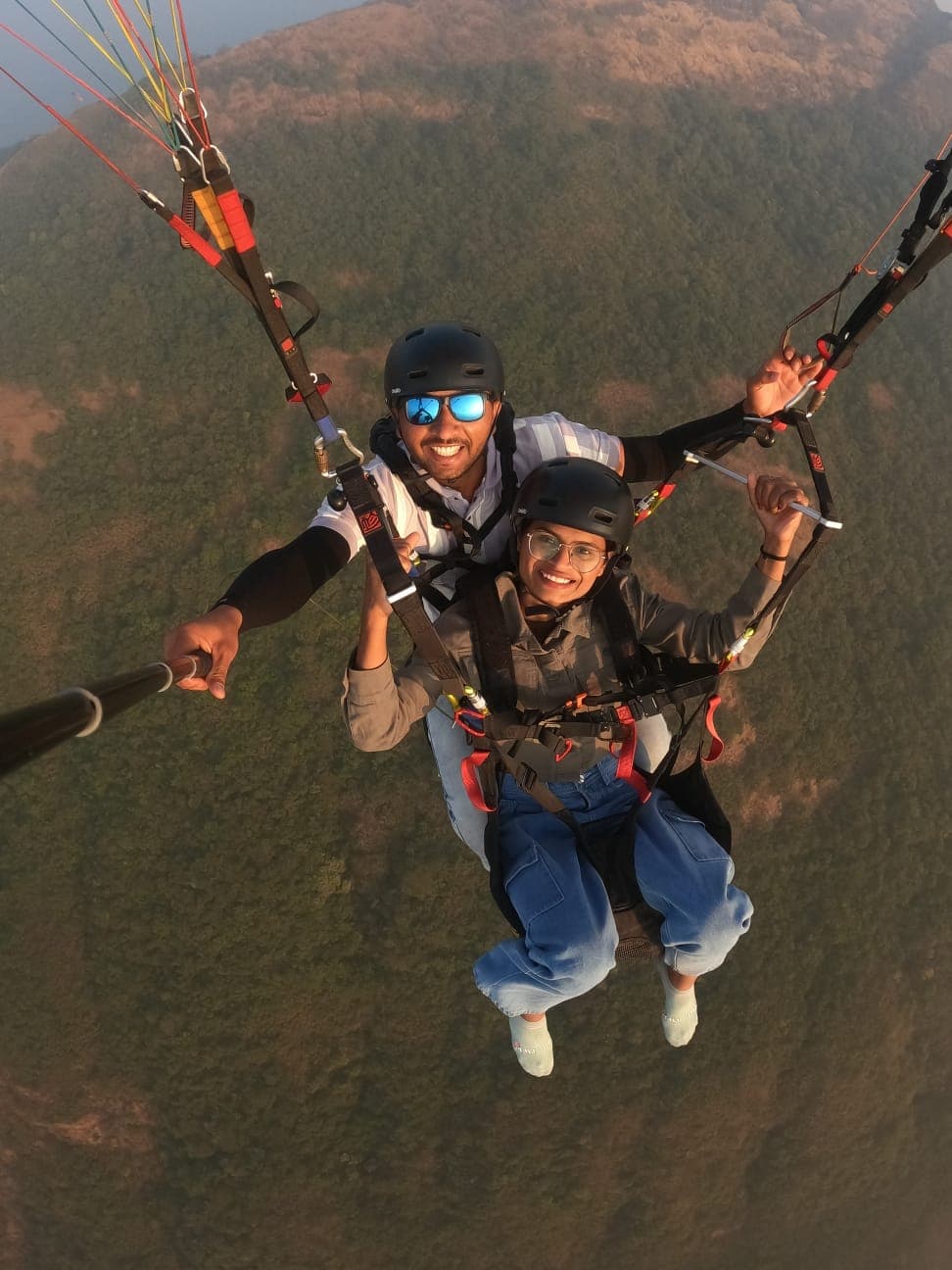 Paraglider gliding past cloud-covered hills near Kamshet Pune