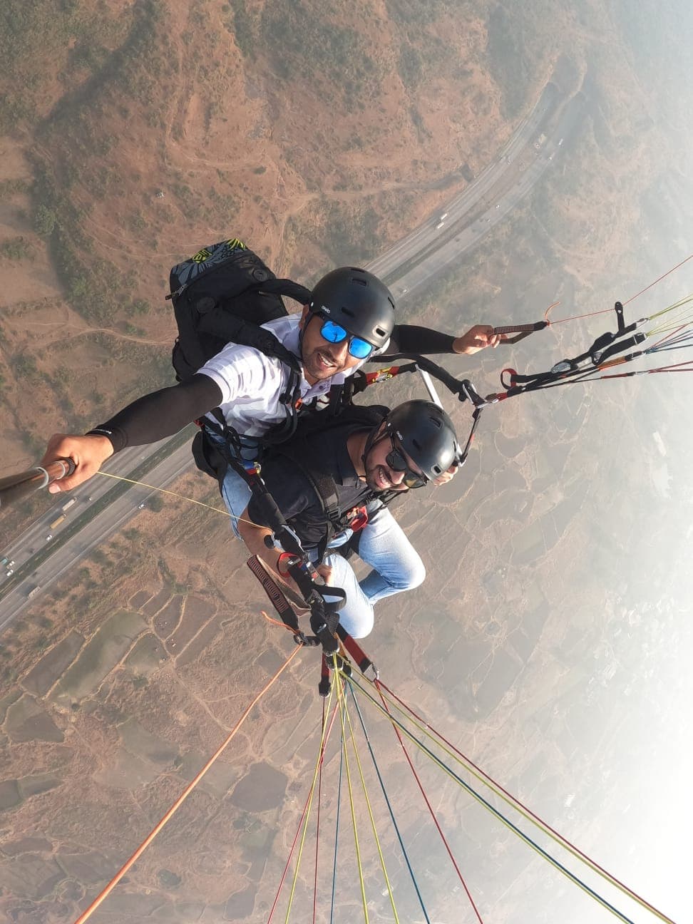 Paragliding instructor briefing passenger before takeoff at Kamshet